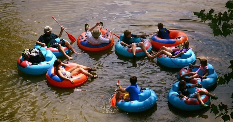 Tubers floating together down a slow river for summer tubing