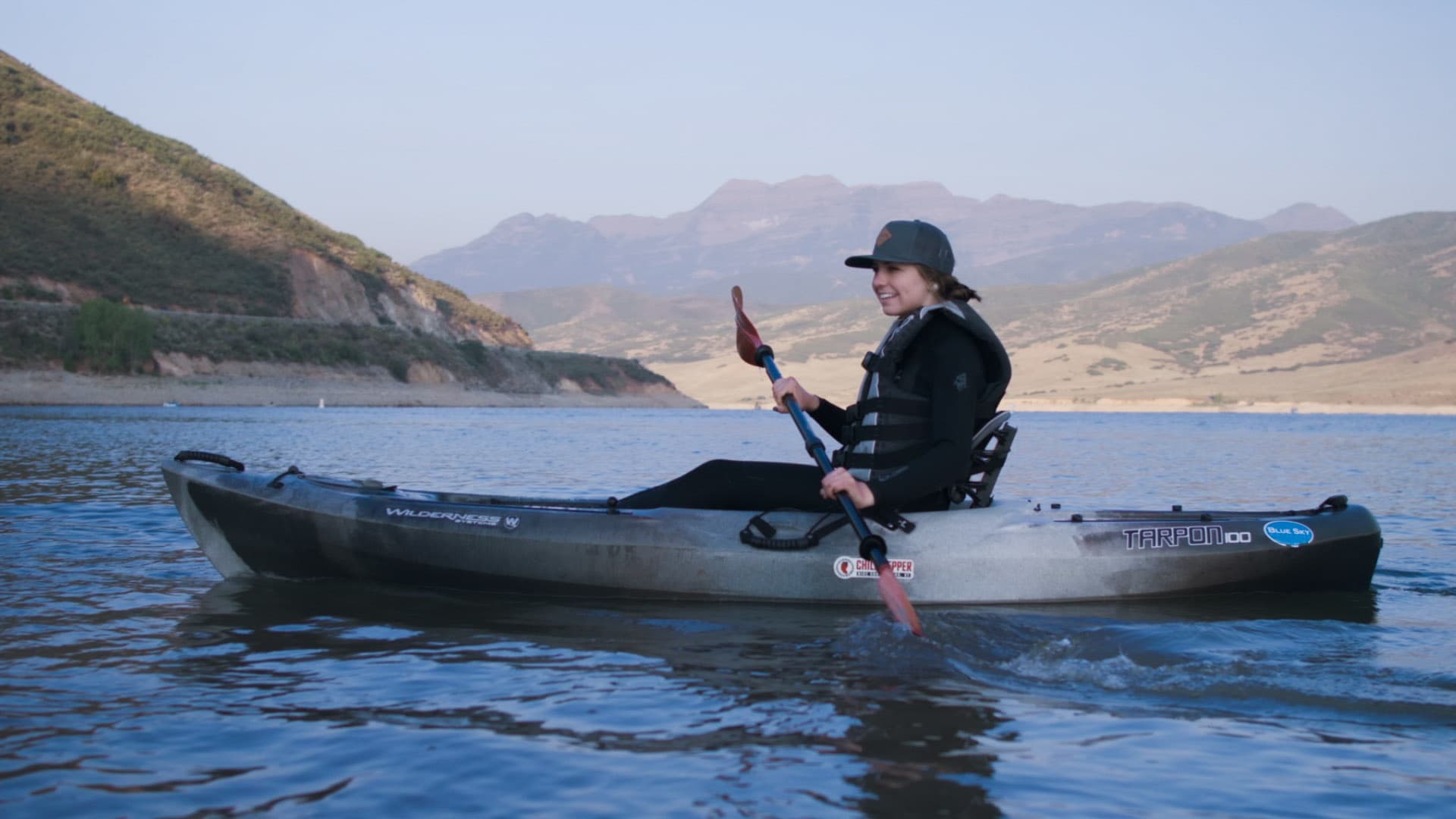 Kayaker paddling on scenic alpine lake at sunrise