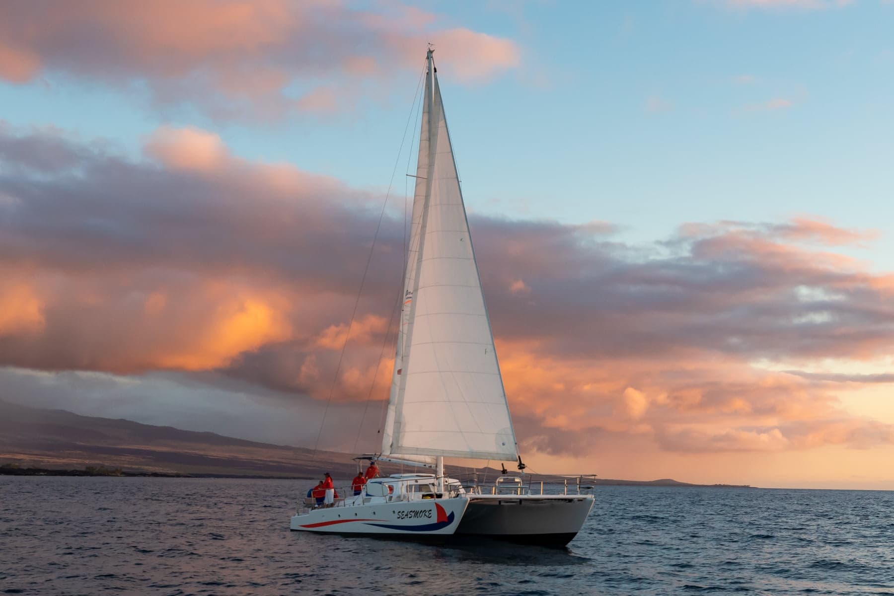 Sailboat cruising at sunset off Hawaii coast, scenic ocean sail