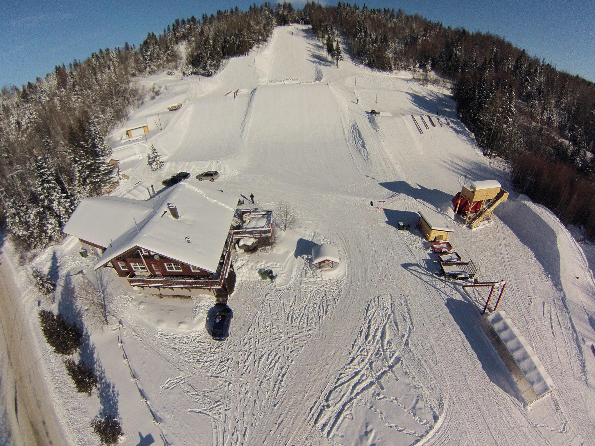 Aerial view of snowy mountain ski resort and groomed trails