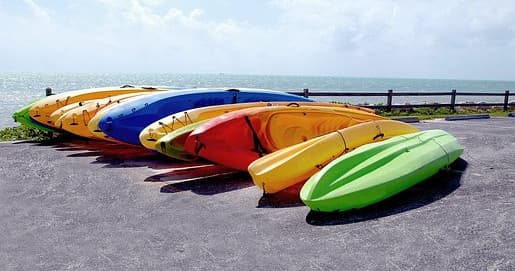 Colorful kayaks lined on waterfront ready for coastal paddling