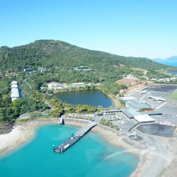 Aerial view of island pier and coastal resort in turquoise waters