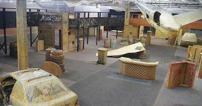 Indoor paintball warehouse with airplane prop and barricades