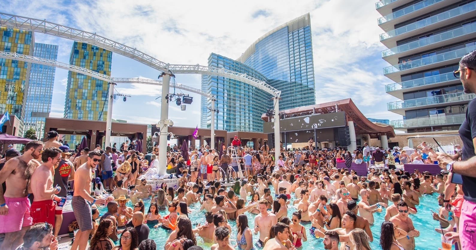 Daytime pool party at Las Vegas resort with skyline view