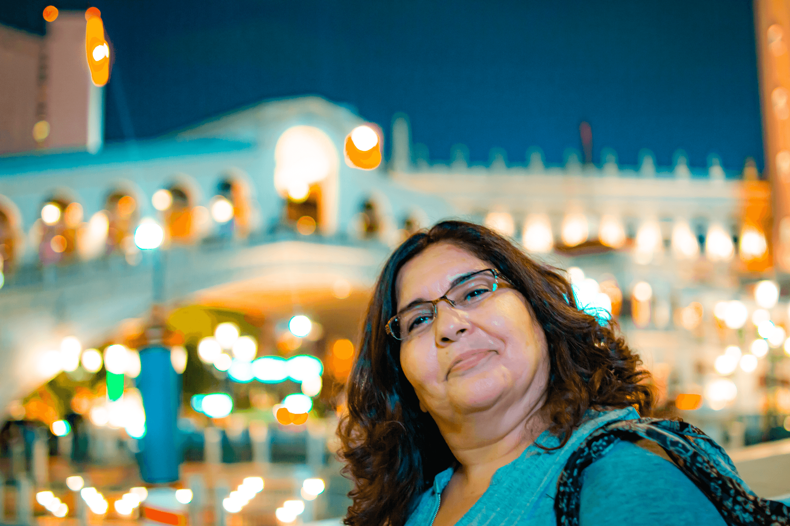 Woman posing in nighttime Las Vegas plaza with bokeh lights
