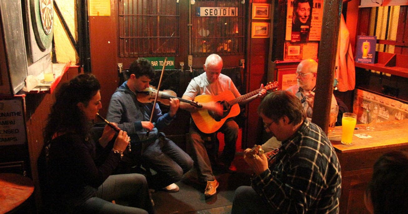 Traditional pub session with musicians playing fiddle and guitar