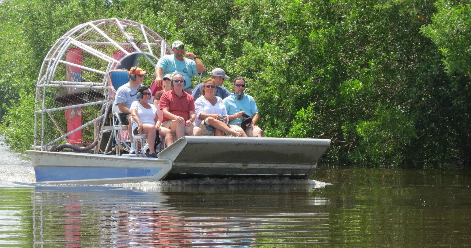 Crowded airboat tour gliding through Everglades mangrove waterways