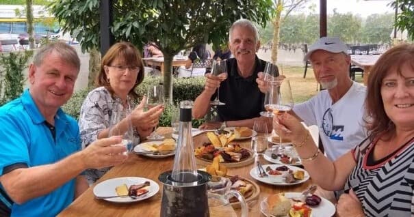 Outdoor friends dining and toasting at rustic alfresco table