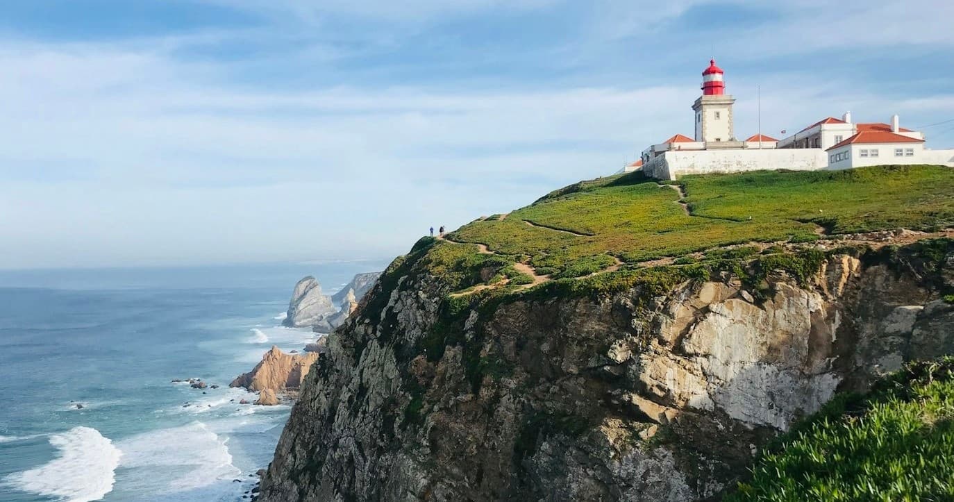 Lighthouse on rugged Atlantic cliff, coastal viewpoint in Portugal