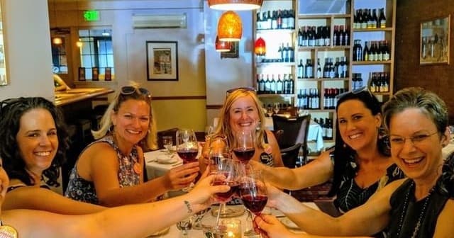 Friends wine tasting indoors at cozy Baltimore restaurant