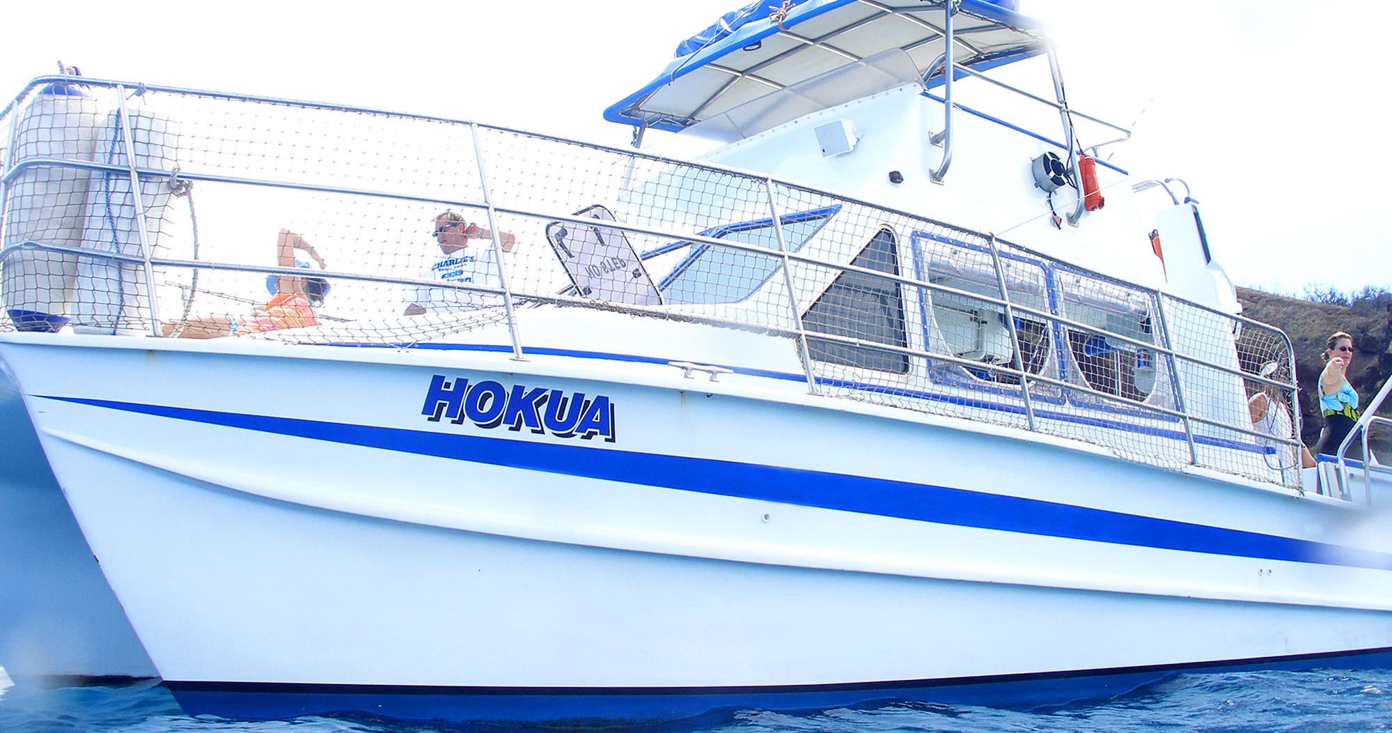 White charter boat HOKUA cruising clear tropical coastal waters