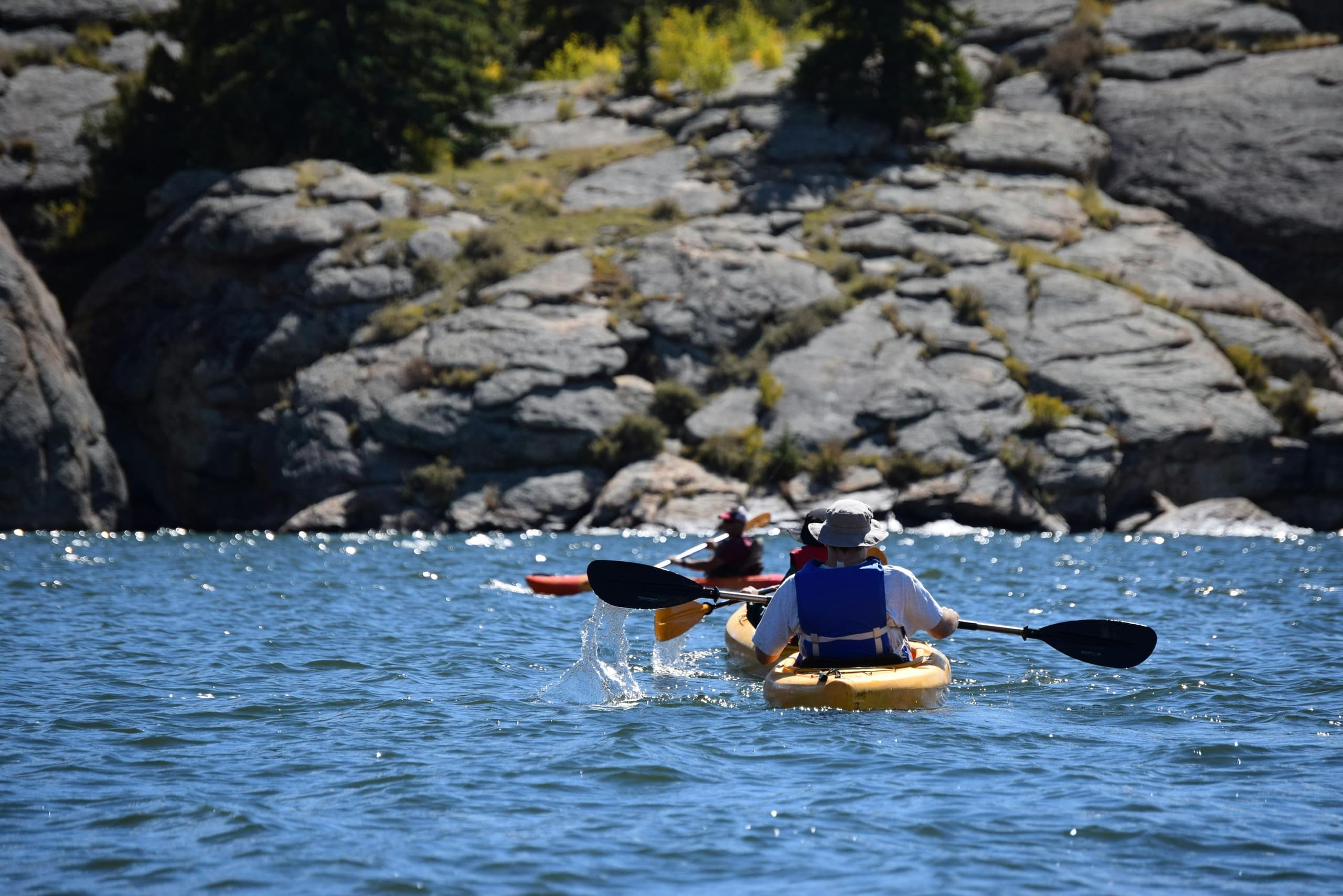 Sea kayakers navigating rocky coastal waters near cliffs