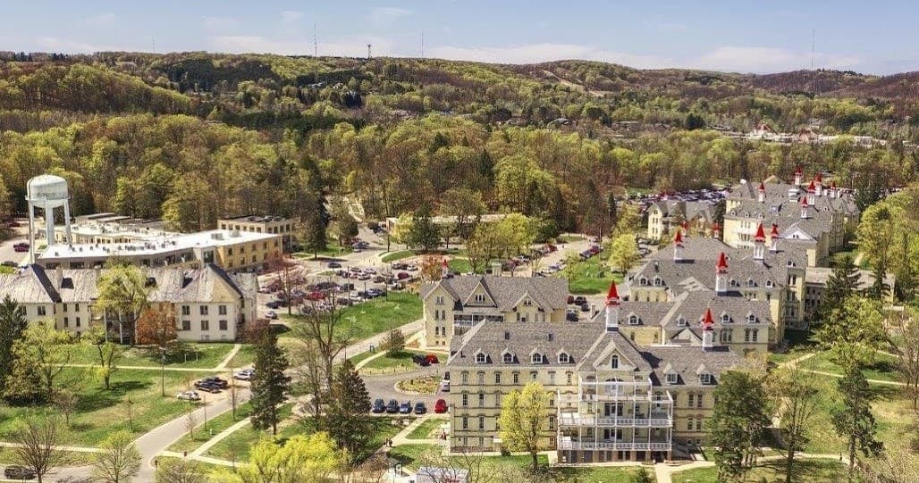 Panoramic aerial view of village campus and surrounding woods