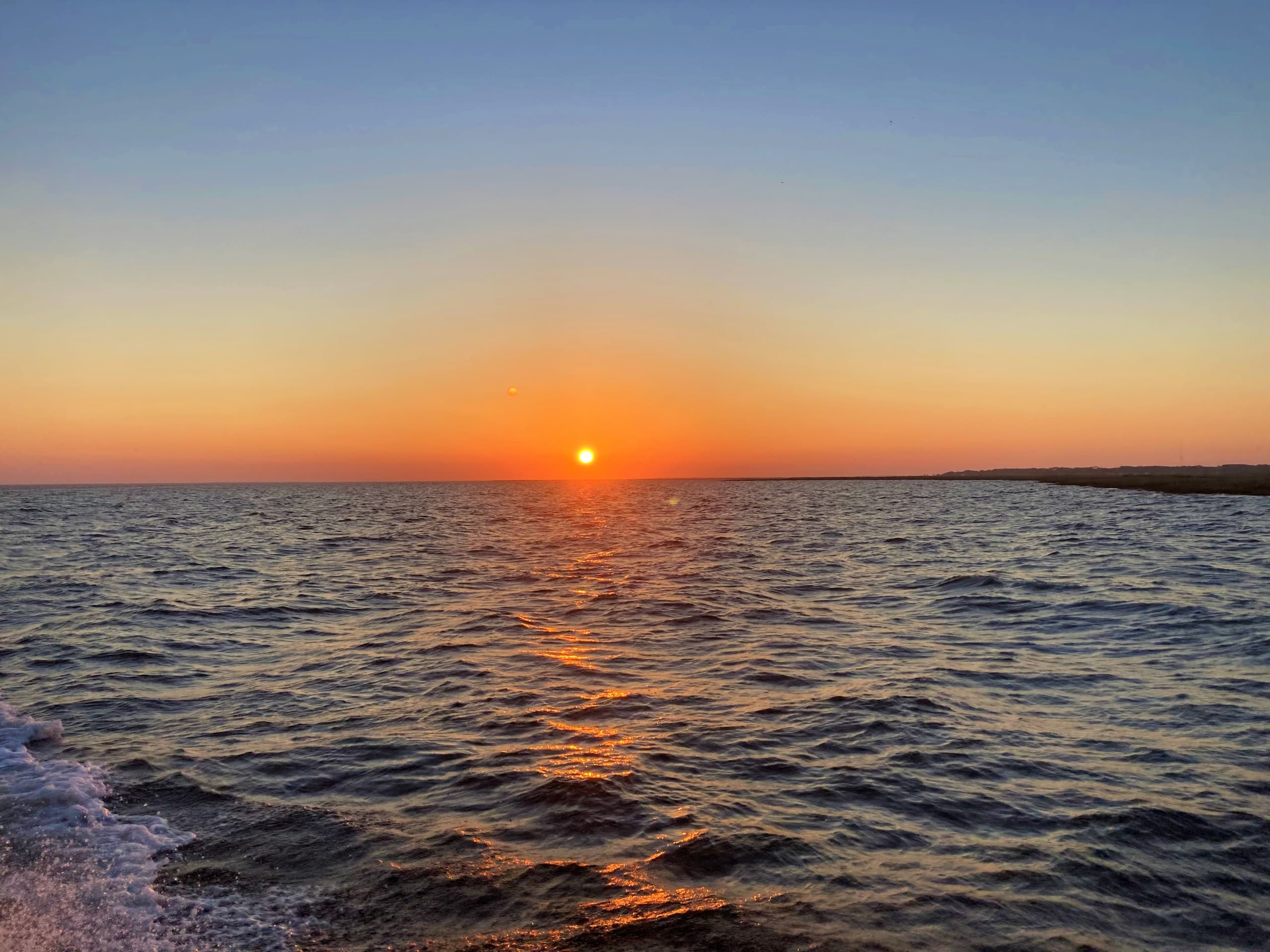 Ocean sunset over calm sea horizon for charter fishing trip