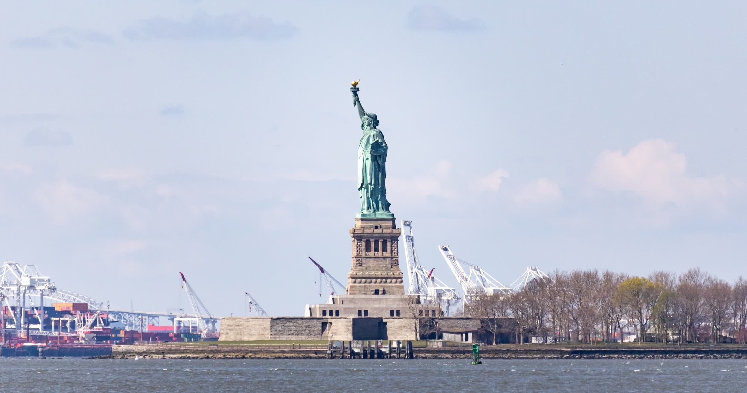 Statue of Liberty standing on Liberty Island with harbor