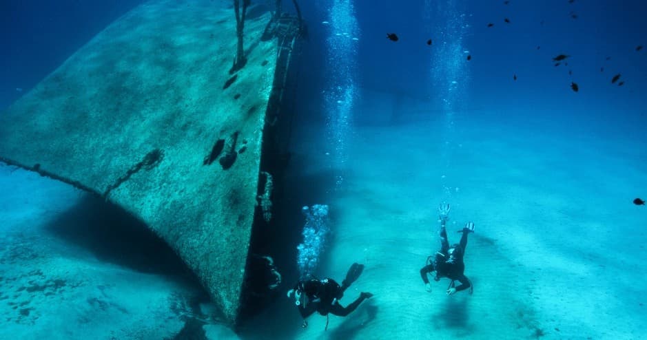 Wreck diving exploration with divers amid historic shipwreck site