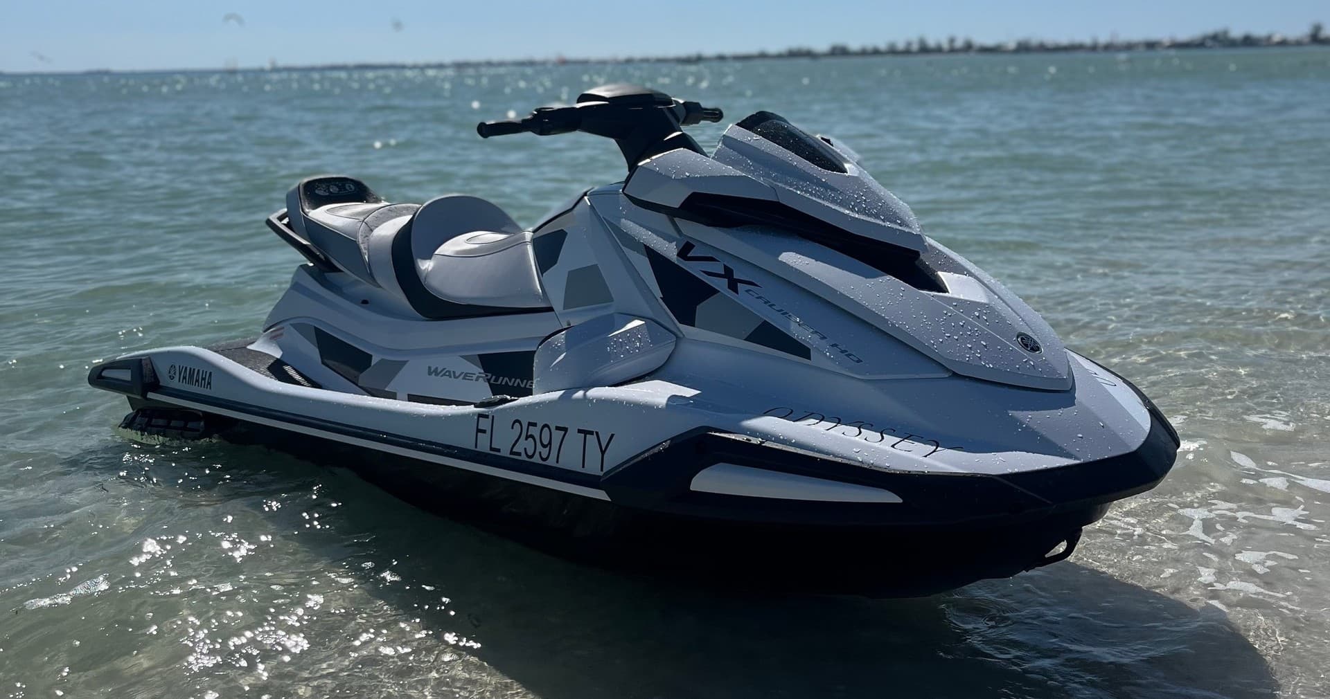 Jet ski parked in shallow coastal waters with sunny horizon