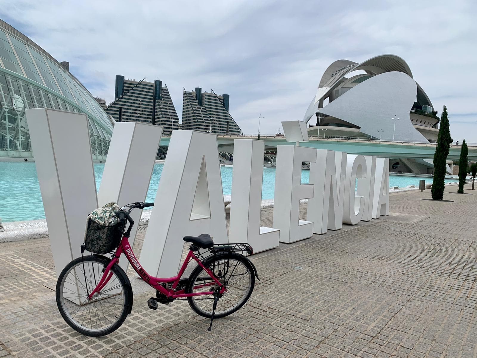 Couple biking past colorful beach cabanas on scenic shoreline