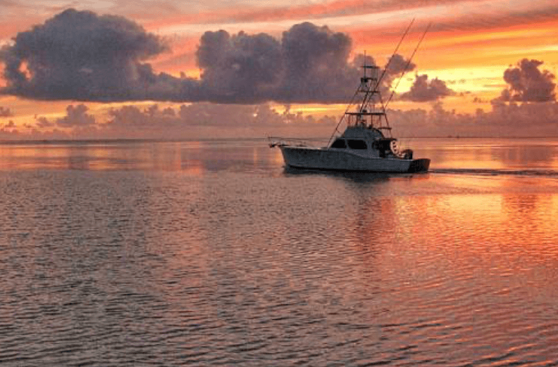 Sportfishing boat at sunrise off Kona, calm ocean fishing trip