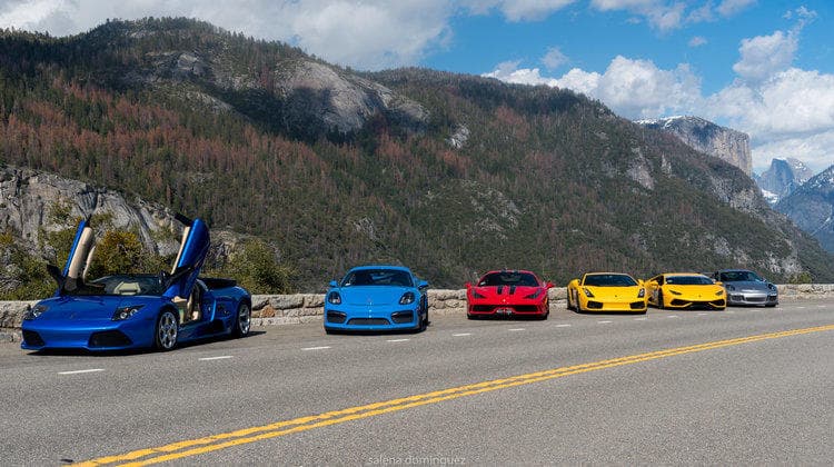 Exotic sports cars lined up on mountain highway scenic drive