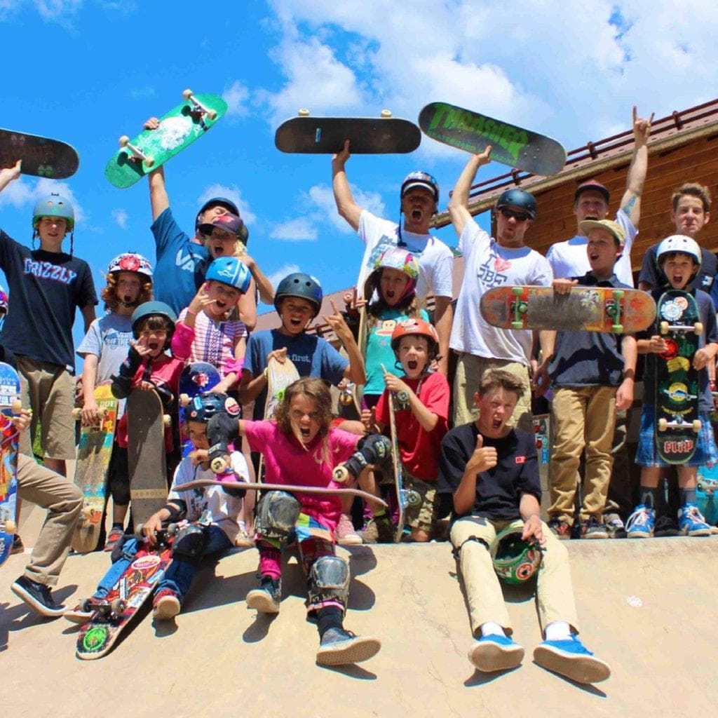 Energetic skate group posing outdoors under blue sky