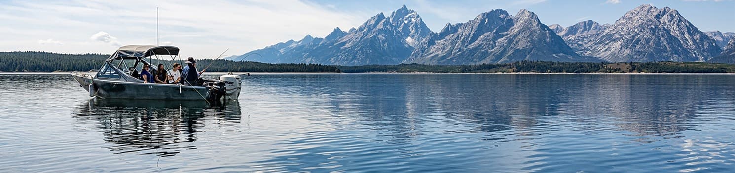 Scenic lake panorama with tour boat and distant mountain range