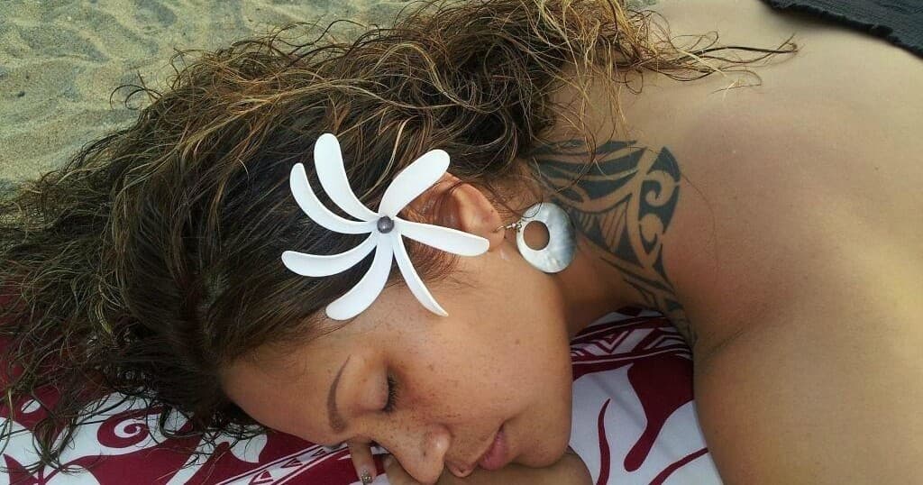 Woman receiving lomi lomi massage on a sandy Hawaiian beach