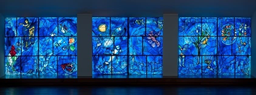 Wide blue stained-glass panels displayed in art gallery