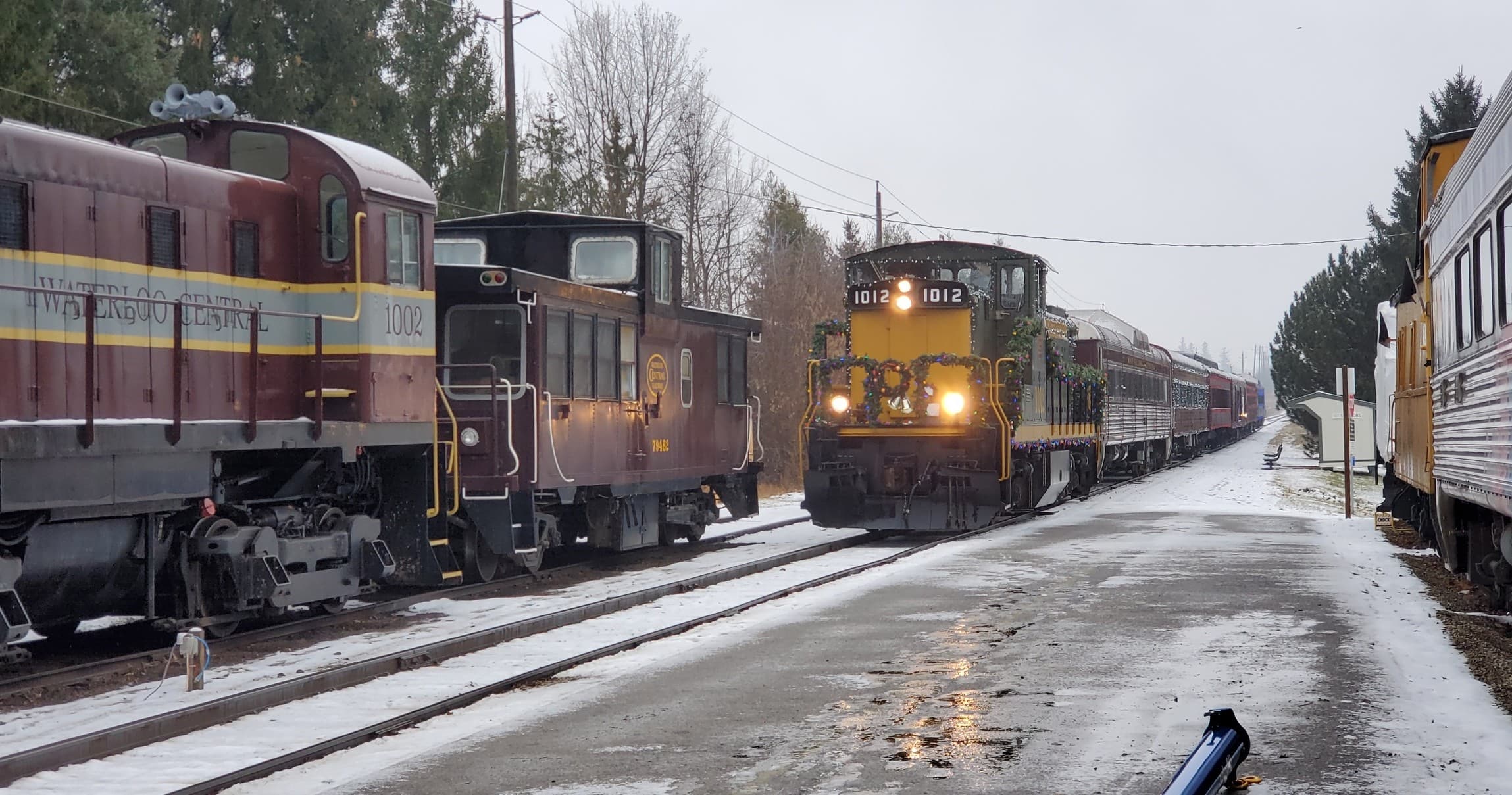 Historic trains idling at snowy station platform on winter railtour