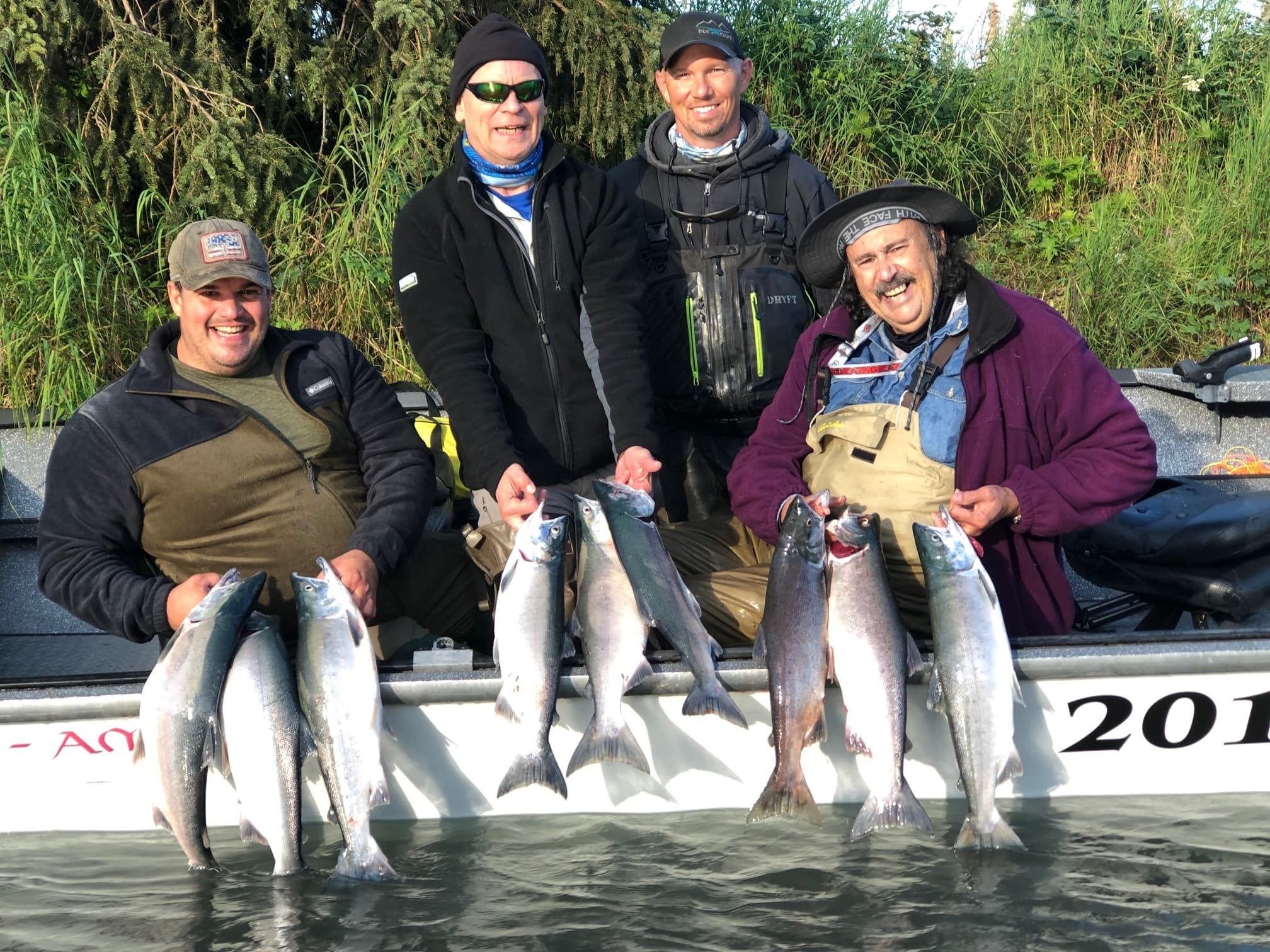 Anglers displaying fresh king salmon on a boat in Alaska