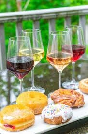 Wine glasses and pastries on outdoor deck with vineyard view
