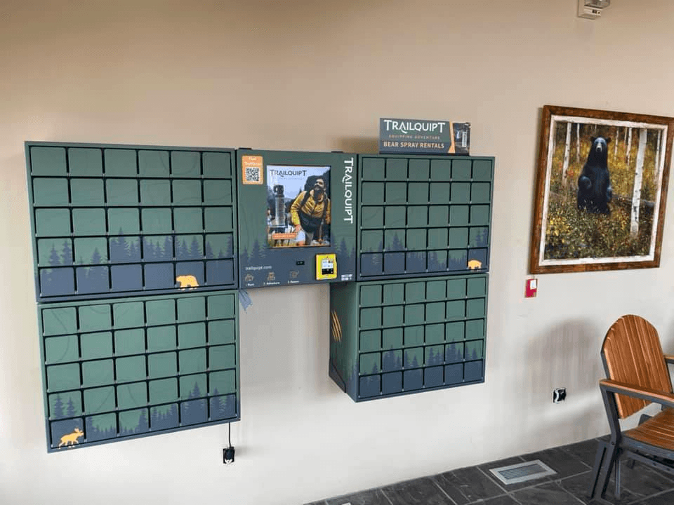 Wall-mounted TrailQuipt bear spray rental lockers inside visitor center