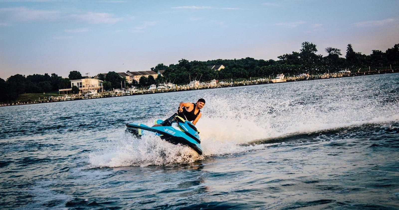 Rider on blue jet ski cutting through choppy bay waters in action