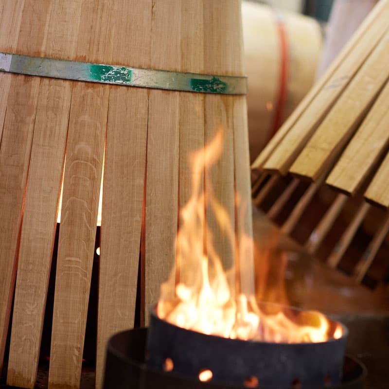 Oak barrel staves being toasted over flame during coopering