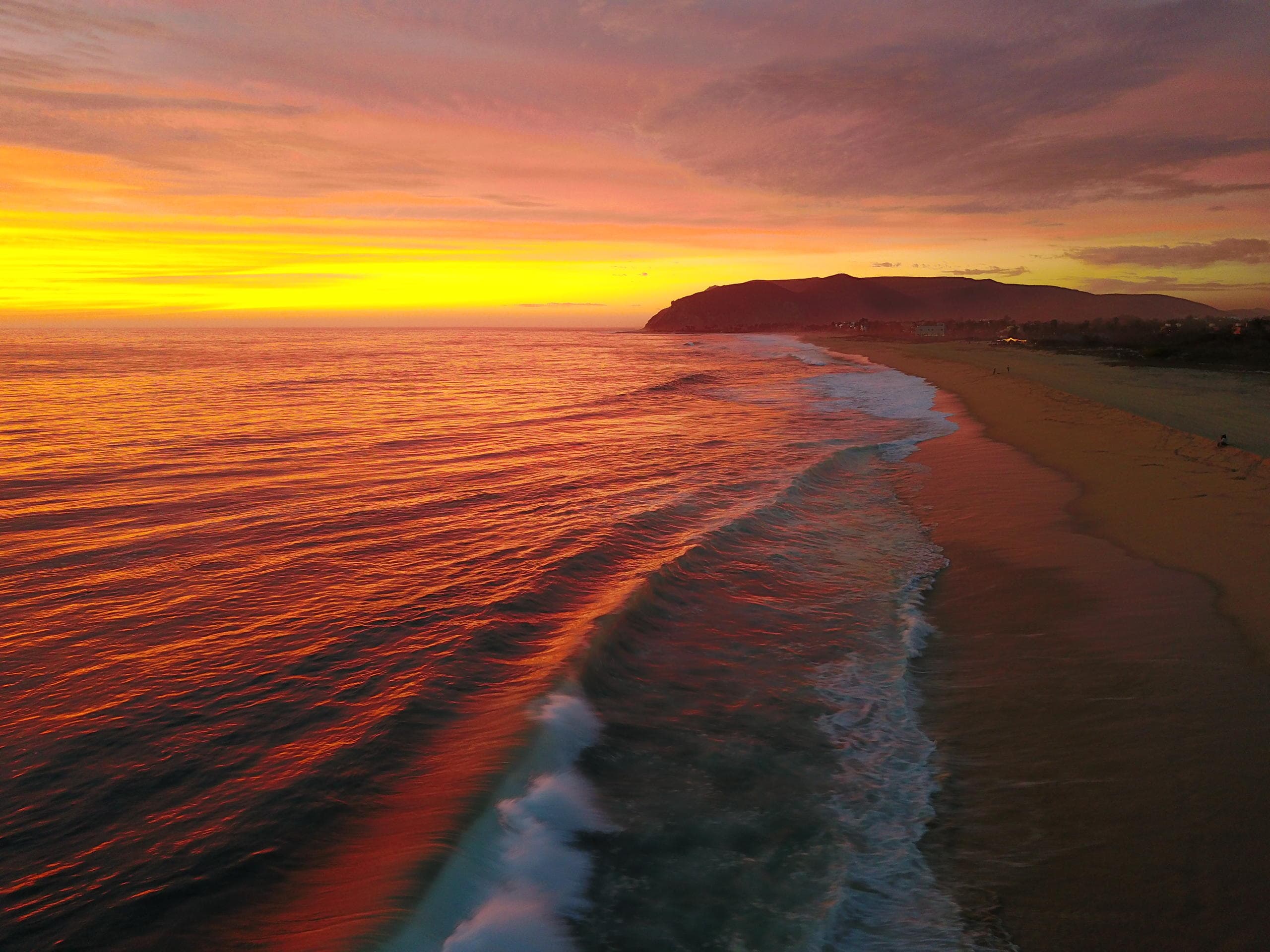 Vibrant coastal sunset over sandy beach, ideal for ocean tours