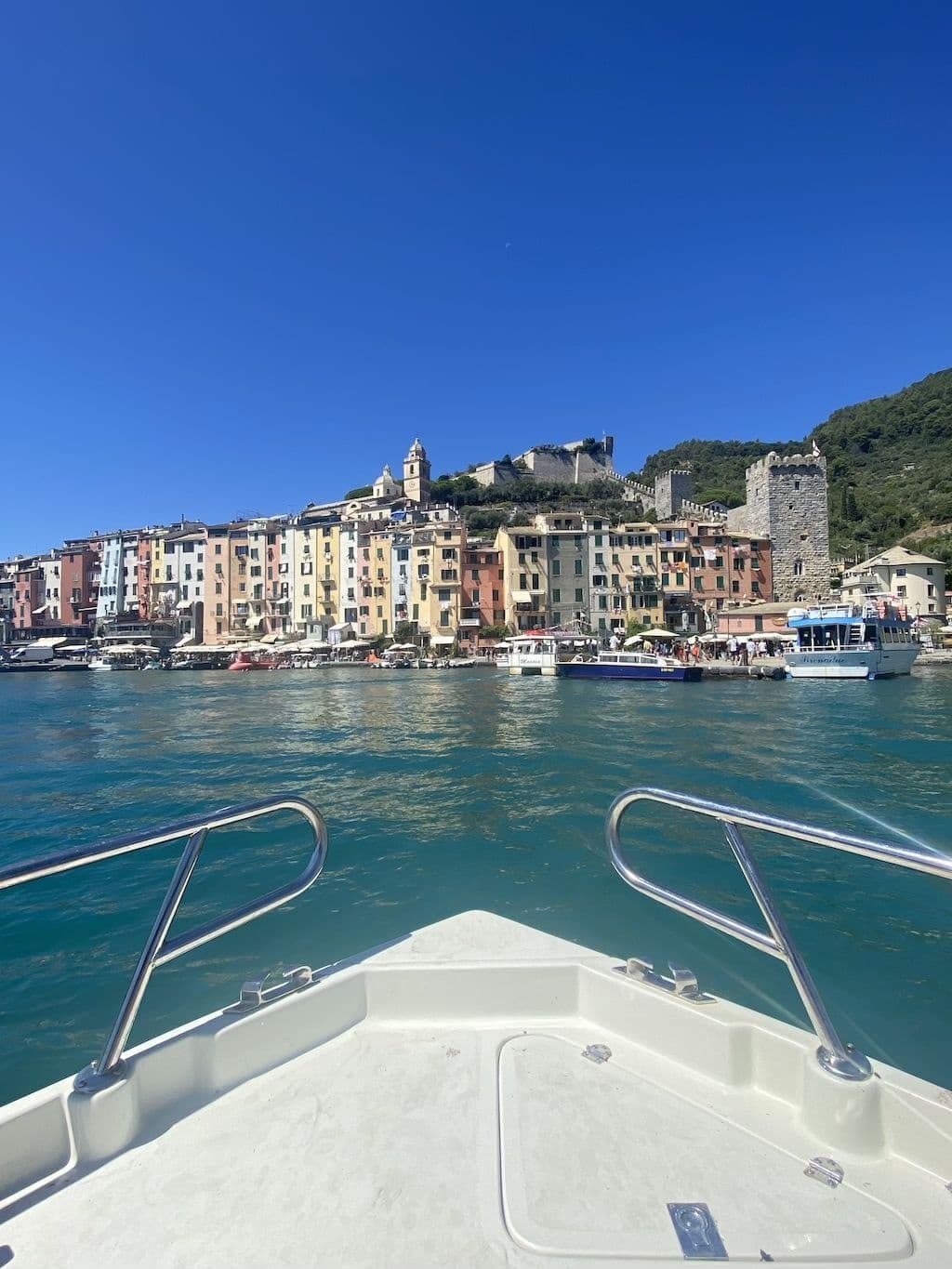Boat approaching colorful Cinque Terre village from the sea