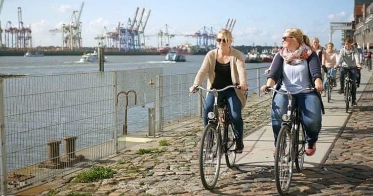 Cyclists riding along Elbe waterfront promenade, Hamburg bike tour