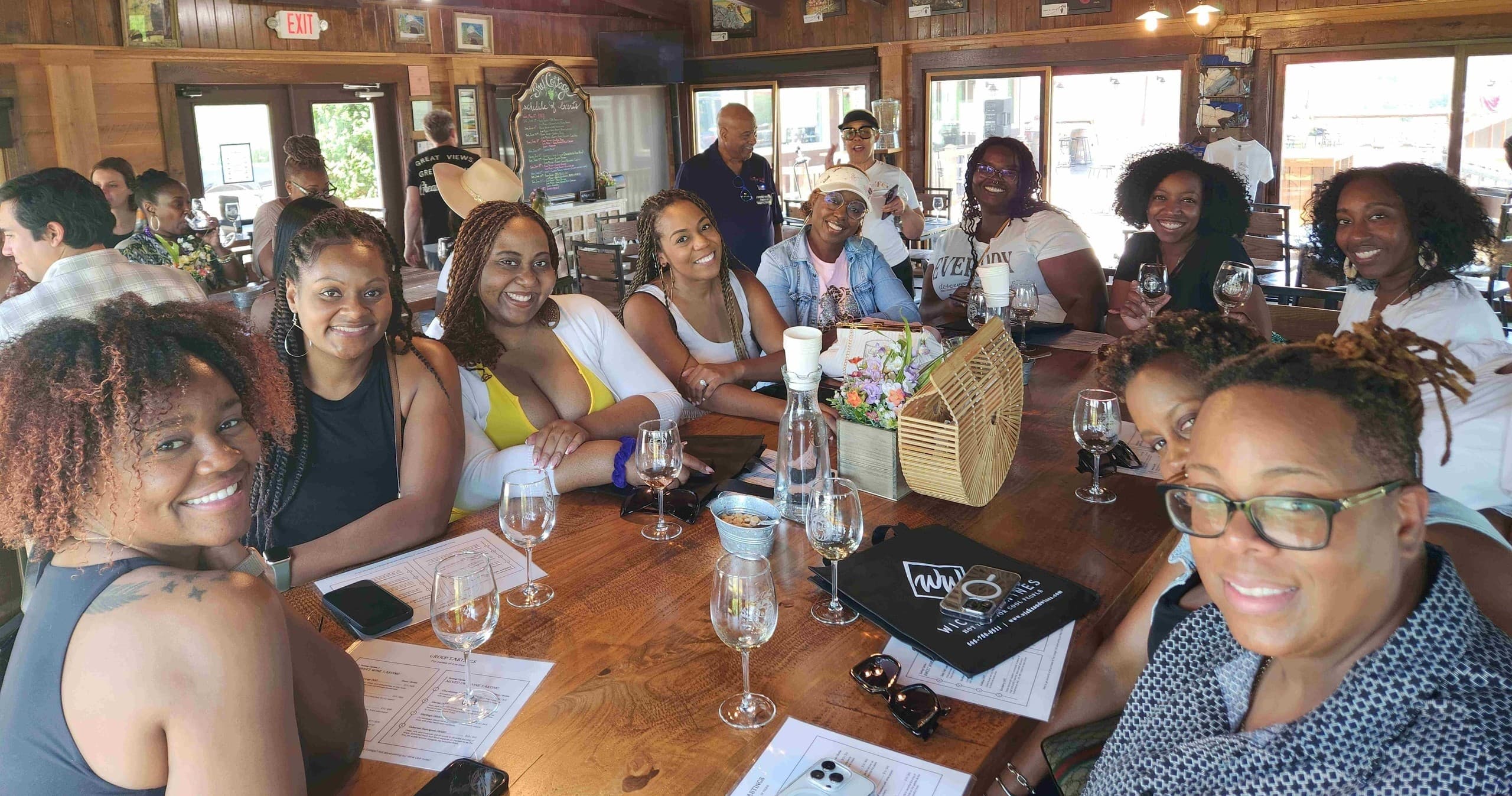 Large group wine tasting inside rustic winery tasting room