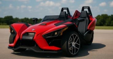 Red Polaris Slingshot on open road under blue sky, scenic drive