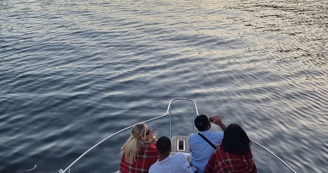 View from boat stern over calm Douro River with passengers aboard