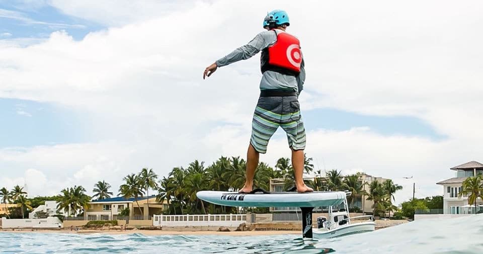Male hydrofoil rider carving over clear blue Caribbean water
