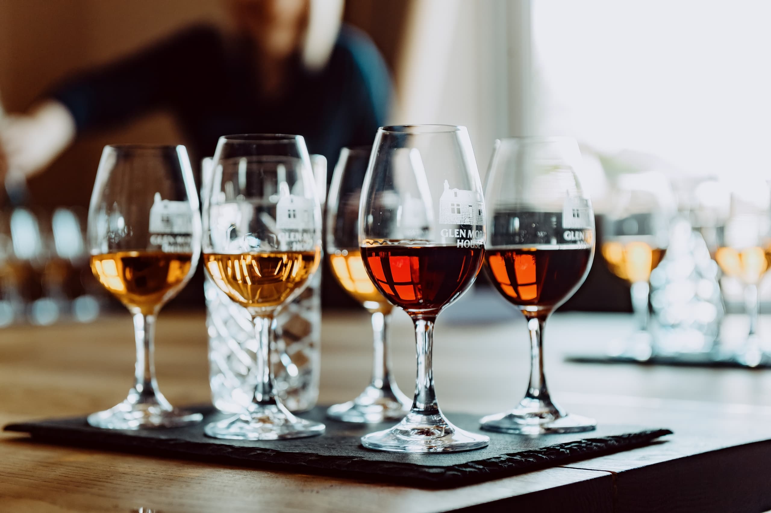 Whisky tasting glasses arranged on wooden bar at Glen Moray