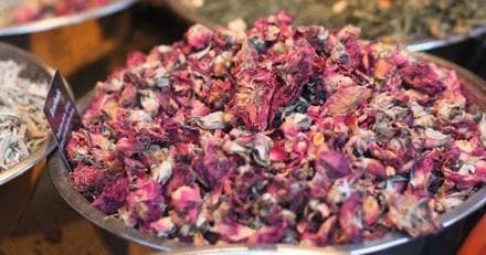 Market bowl of dried rose petals at outdoor spice market