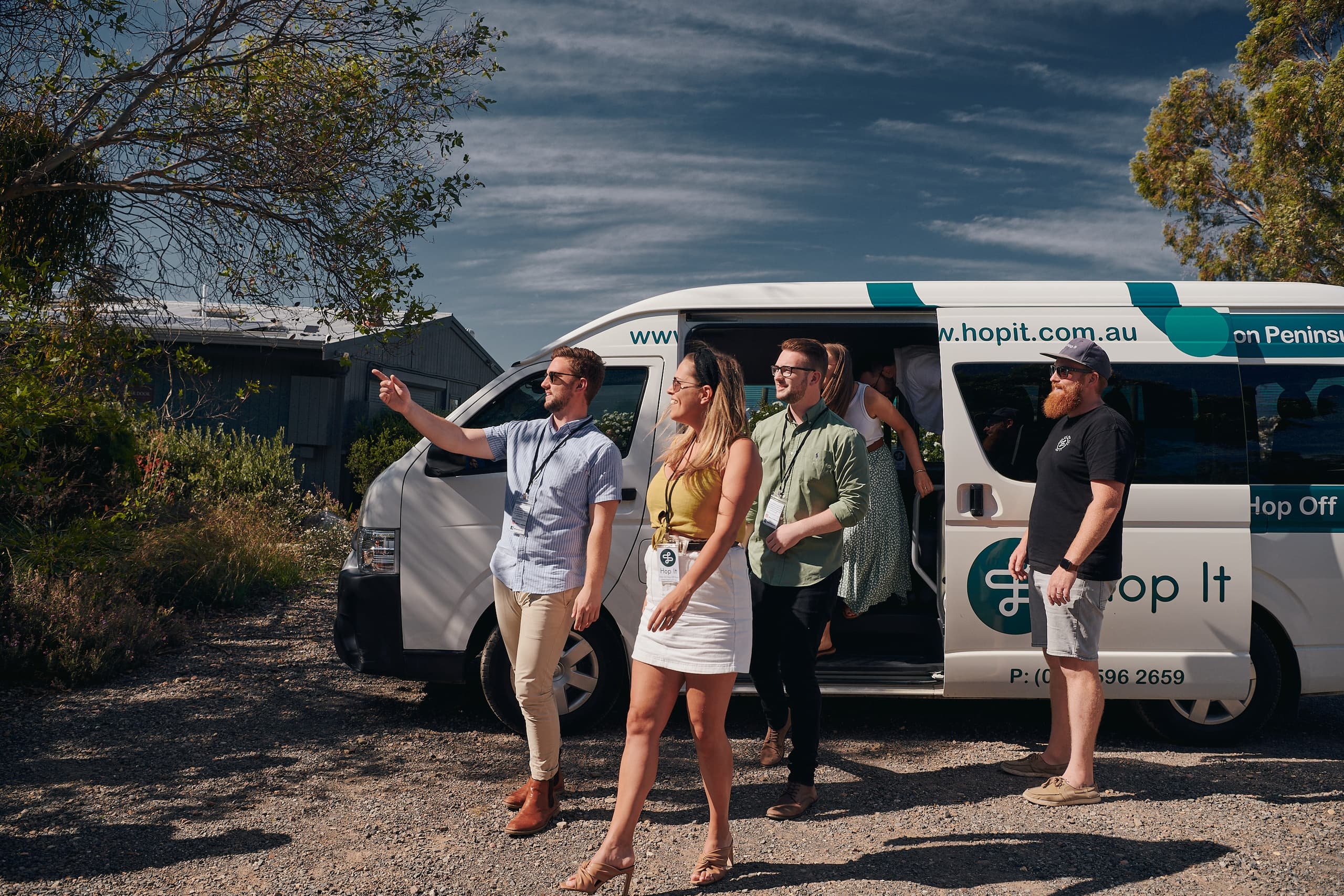 Group boarding Hop It shuttle at rural winery parking, tour start
