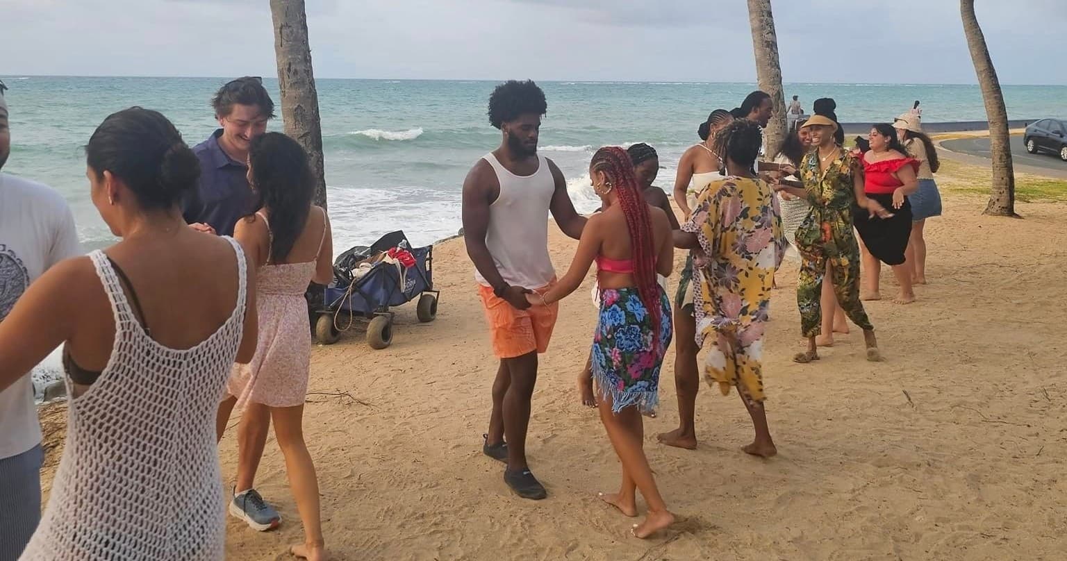 Beach salsa dancers socializing on sandy oceanfront shore