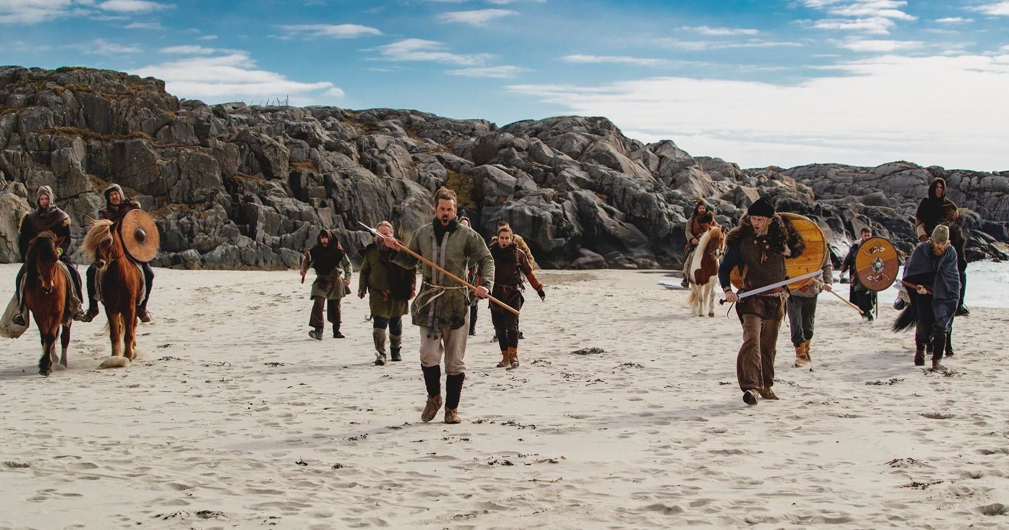 Viking crew marching along rocky sandy beach during shore raid