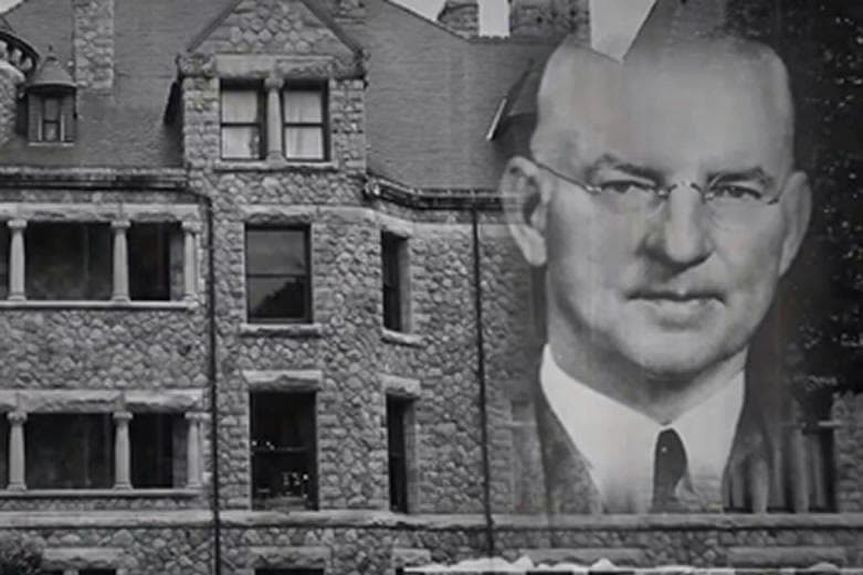 Black-and-white historic mansion projection with professor portrait, indoor