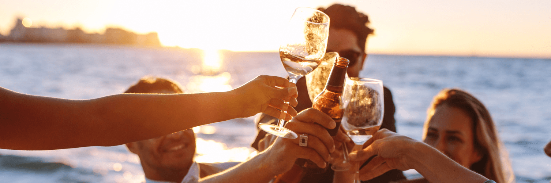 Friends toasting on a boat at sunset on open ocean cruise