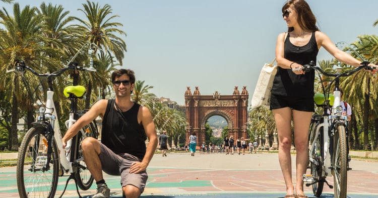 Couple with bikes near Arc de Triomf in Barcelona park