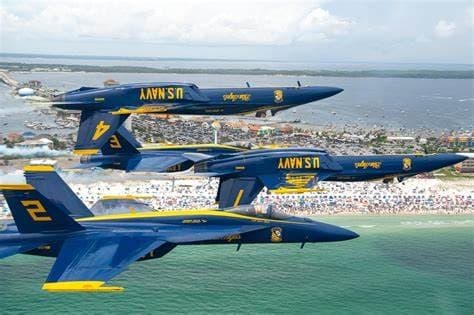 Aerial Blue Angels jet demonstration flying low over shoreline crowd